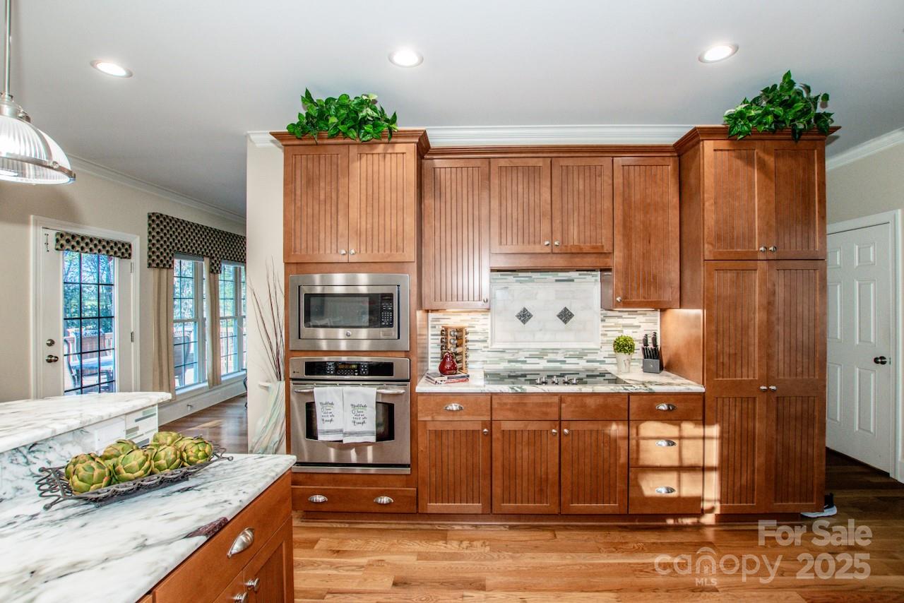 570 Morrison Farm Road Troutman, NC 28166 - Photo 12 of 32 a kitchen with kitchen island granite countertop wooden cabinets and a stove