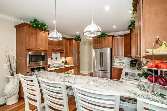 a kitchen with a refrigerator a stove and a wooden floor