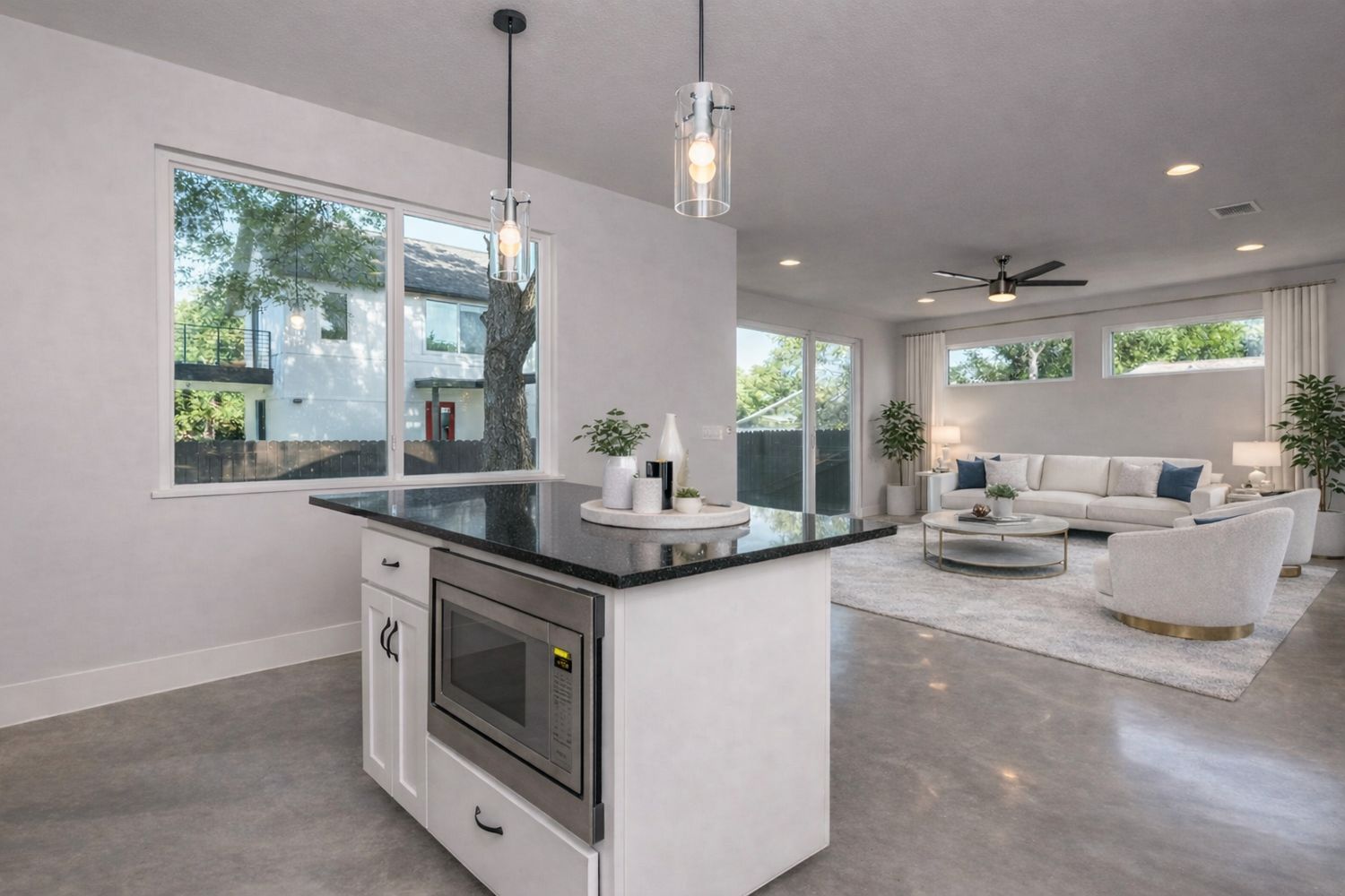 1182 Ridgeway Drive, Unit A Austin, TX 78702 - Photo 27 of 27 Kitchen with concrete floors, stainless steel microwave, a kitchen island, open floor plan, and hanging light fixtures