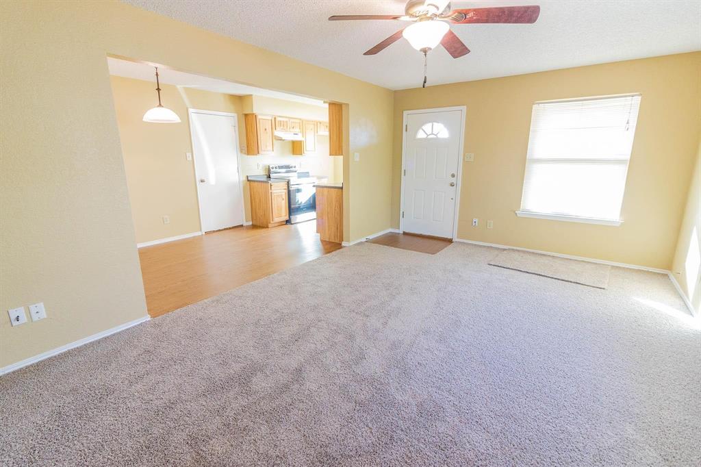 1007 Phillips Circle Kaufman, TX 75142 - Photo 2 of 12 an empty room with a chandelier and a window