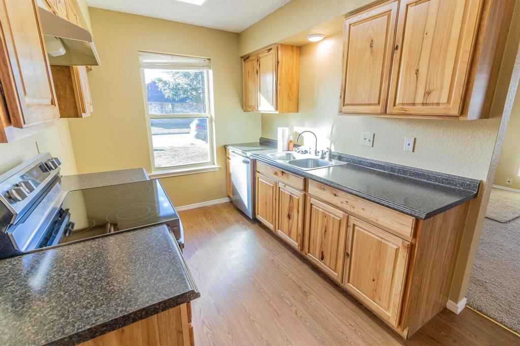 1007 Phillips Circle Kaufman, TX 75142 - Photo 4 of 12 a kitchen with stainless steel appliances granite countertop a sink stove and cabinets