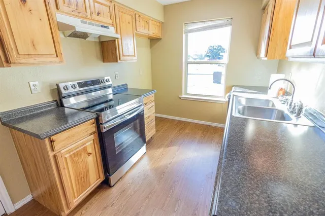 a kitchen with stainless steel appliances granite countertop a sink stove and cabinets