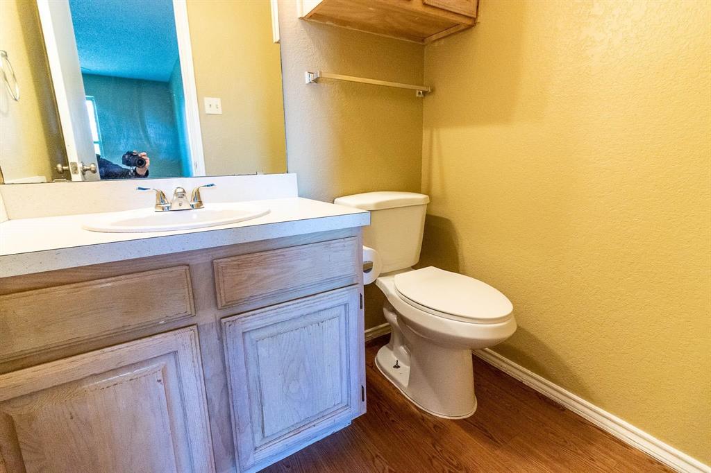 1007 Phillips Circle Kaufman, TX 75142 - Photo 8 of 12 a bathroom with a toilet a sink and wooden floor
