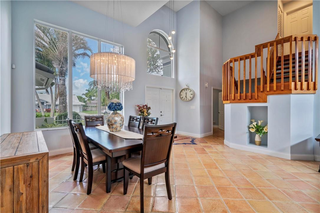 9695 West Lake Court Boca Raton, FL 33434 - Photo 12 of 43 a view of a dining room with furniture and a chandelier