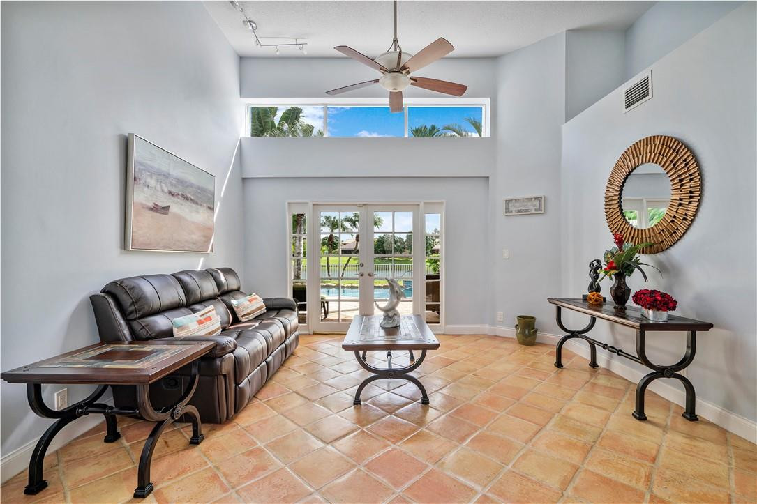 9695 West Lake Court Boca Raton, FL 33434 - Photo 15 of 43 a living room with furniture a chandelier and a floor to ceiling window