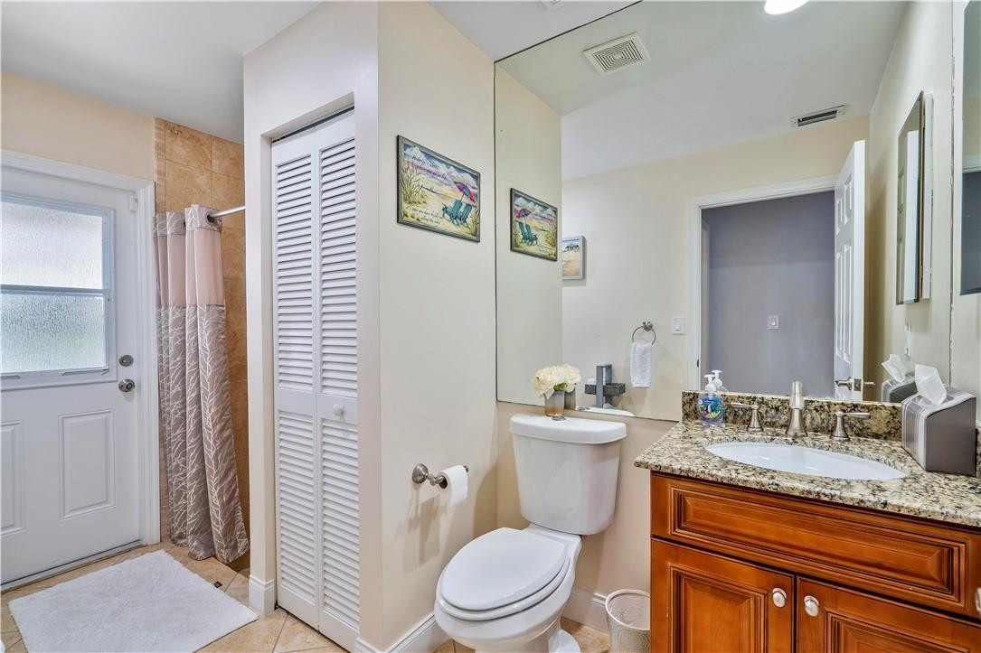 9695 West Lake Court Boca Raton, FL 33434 - Photo 17 of 43 a bathroom with a granite countertop toilet a sink and a mirror