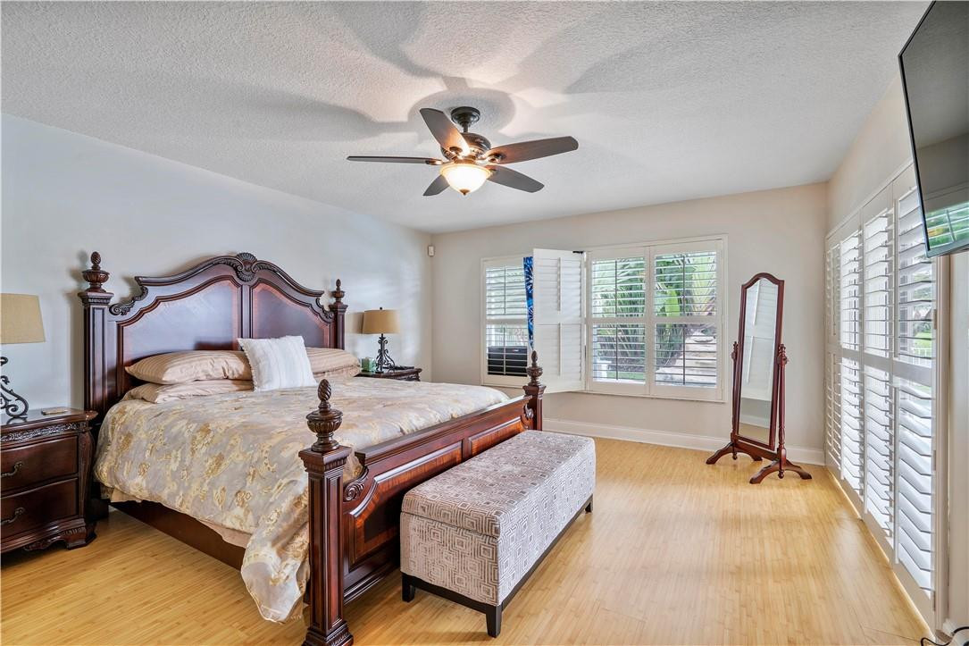 9695 West Lake Court Boca Raton, FL 33434 - Photo 19 of 43 a bedroom with a bed and a chandelier