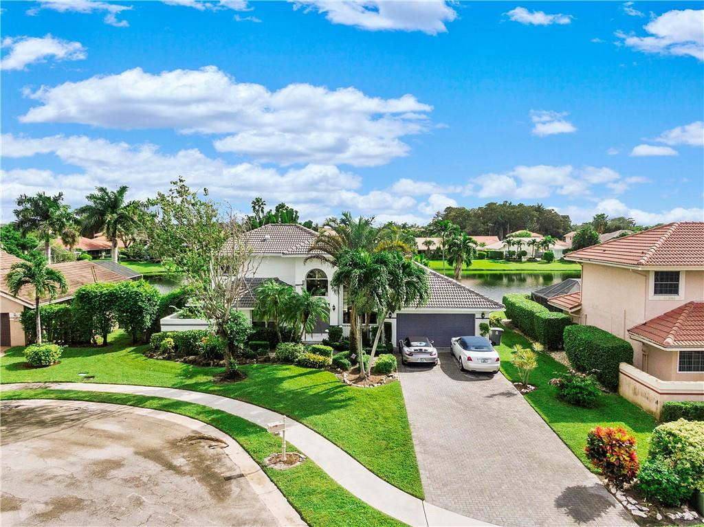 9695 West Lake Court Boca Raton, FL 33434 - Photo 39 of 43 a view of house with a yard and table and chair