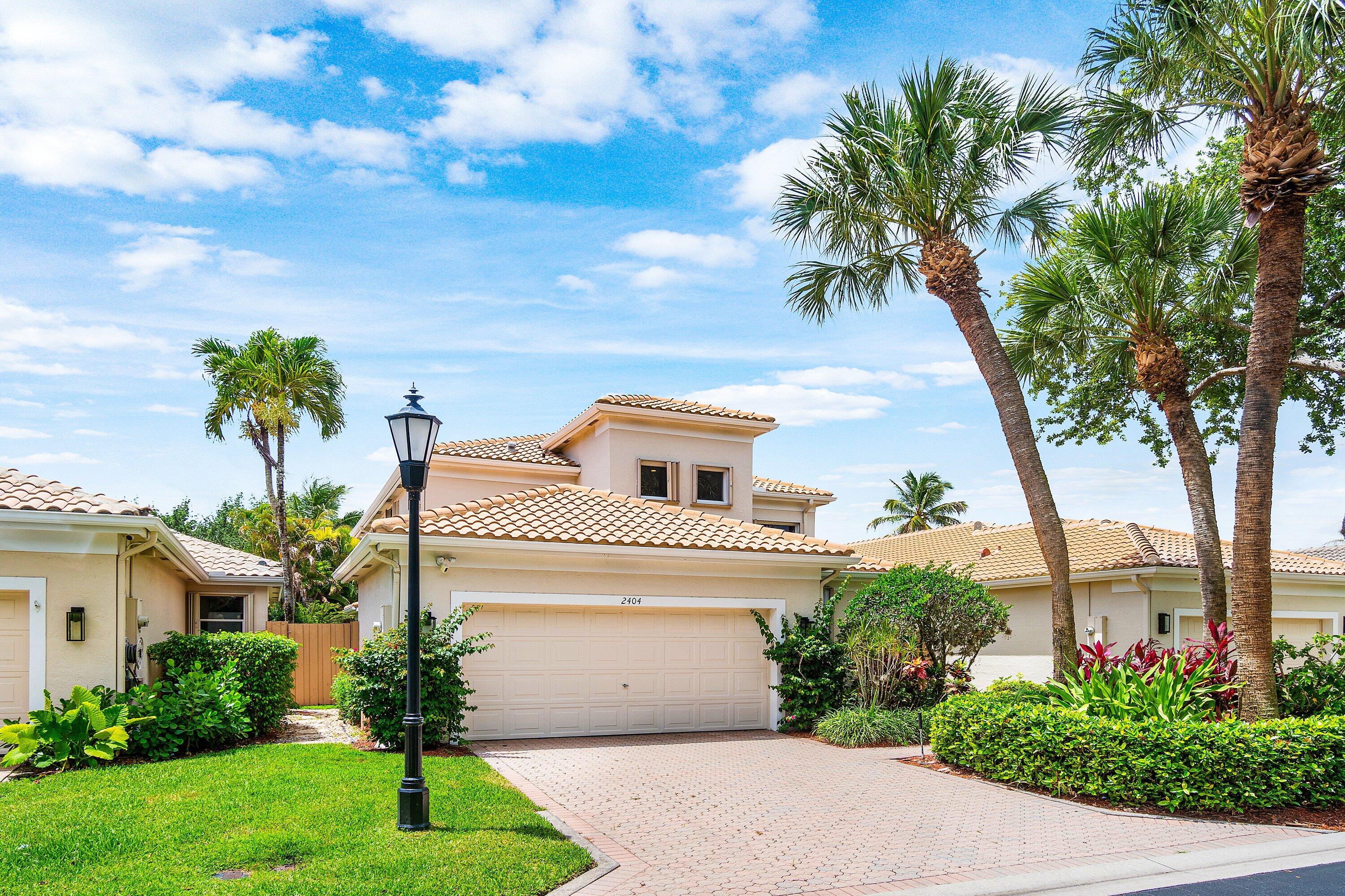 2404 Northwest 67th Street Boca Raton, FL 33496 - Photo 2 of 74 a front view of a house with a garden