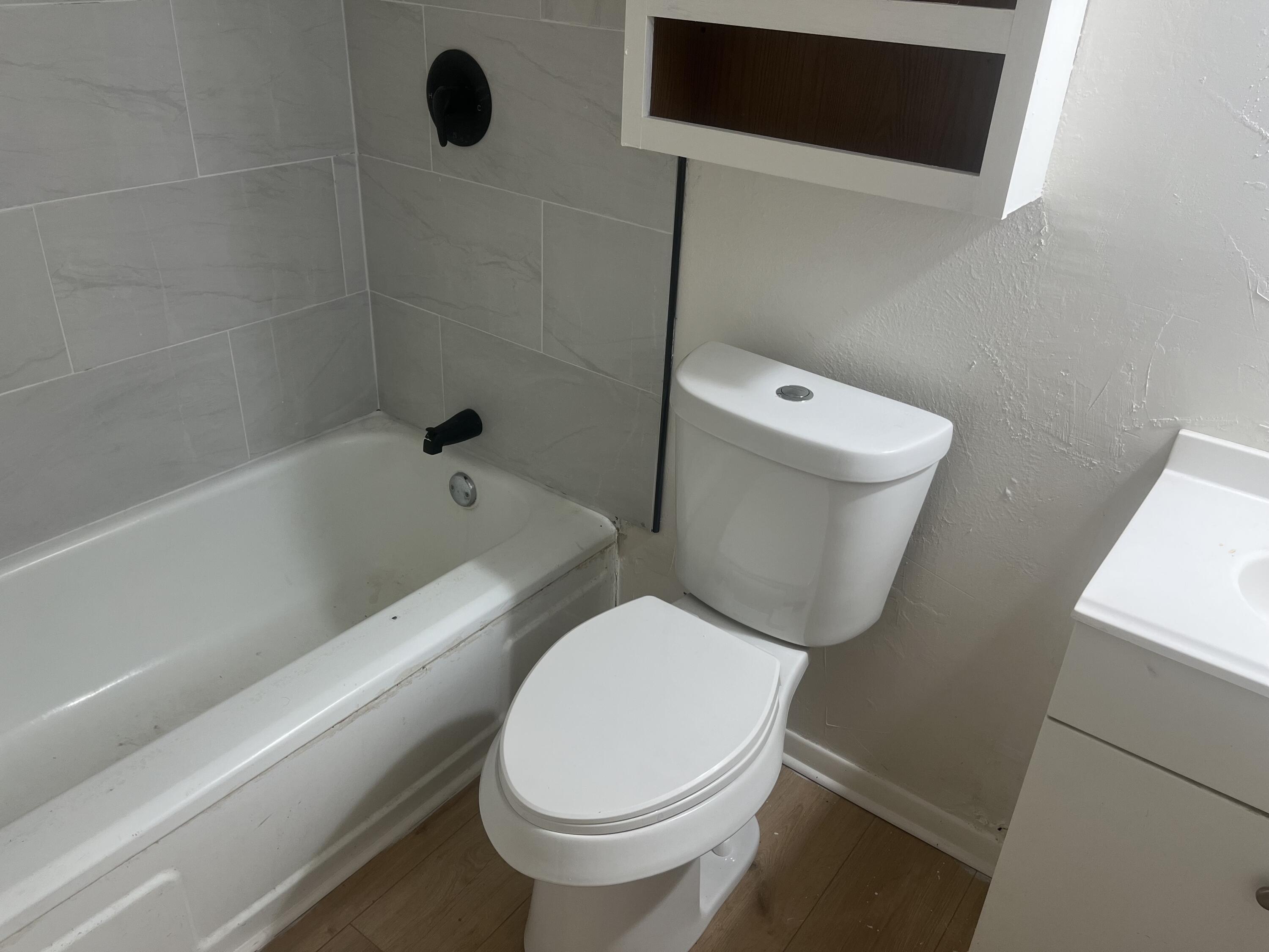 1906 70th Street Lubbock, TX 79412 - Photo 16 of 27 a white toilet sitting next to a bath tub
