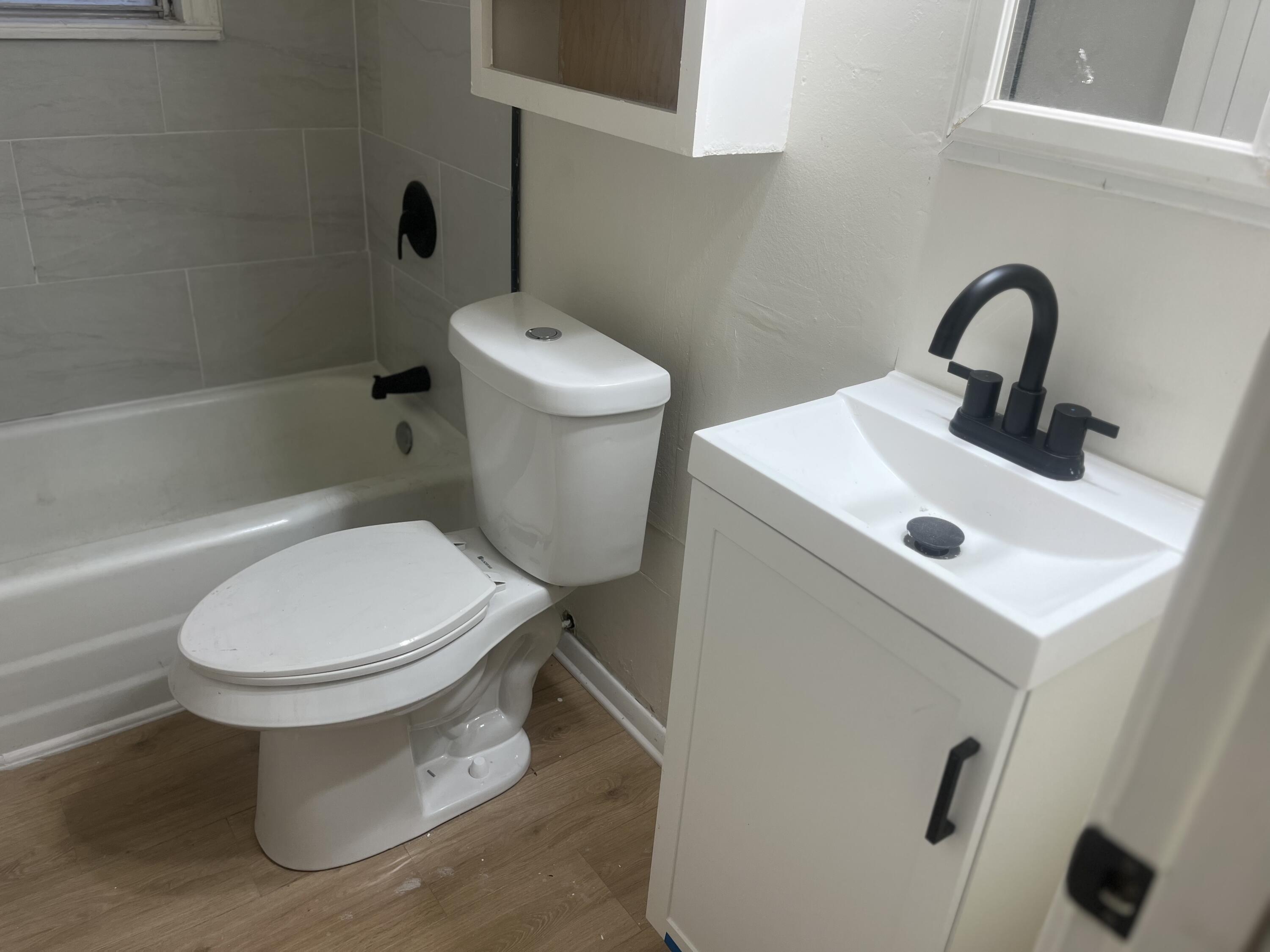 1906 70th Street Lubbock, TX 79412 - Photo 22 of 27 a white toilet sitting next to a bathroom sink