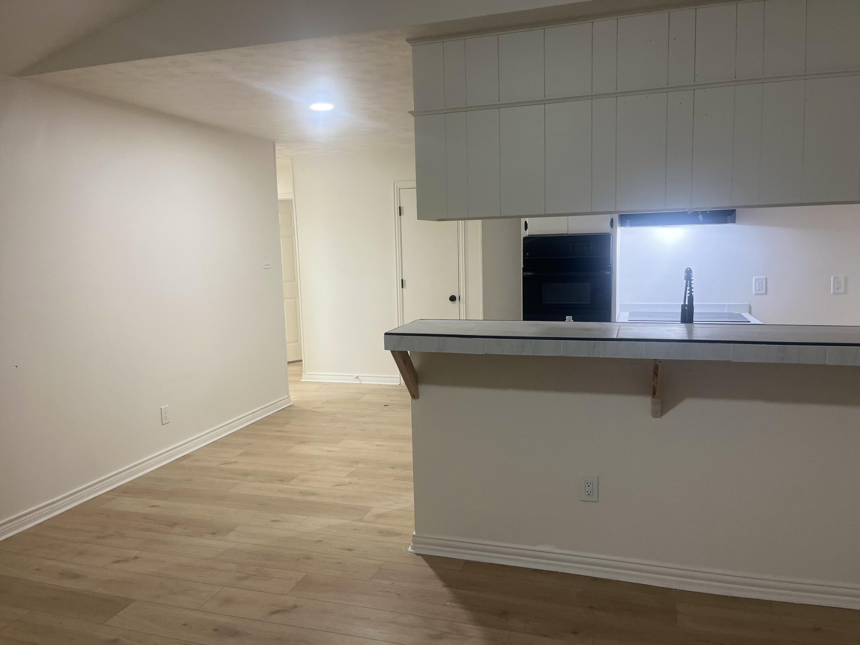 1906 70th Street Lubbock, TX 79412 - Photo 3 of 27 a view of cabinets with stainless steel appliances wooden floor and living room