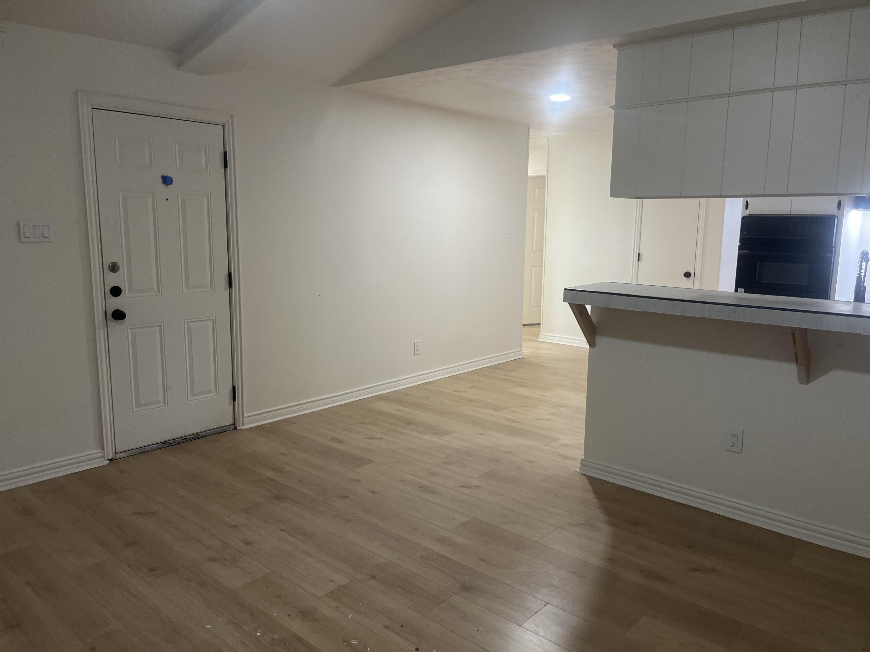 1906 70th Street Lubbock, TX 79412 - Photo 4 of 27 an empty room with wooden floor and cabinet
