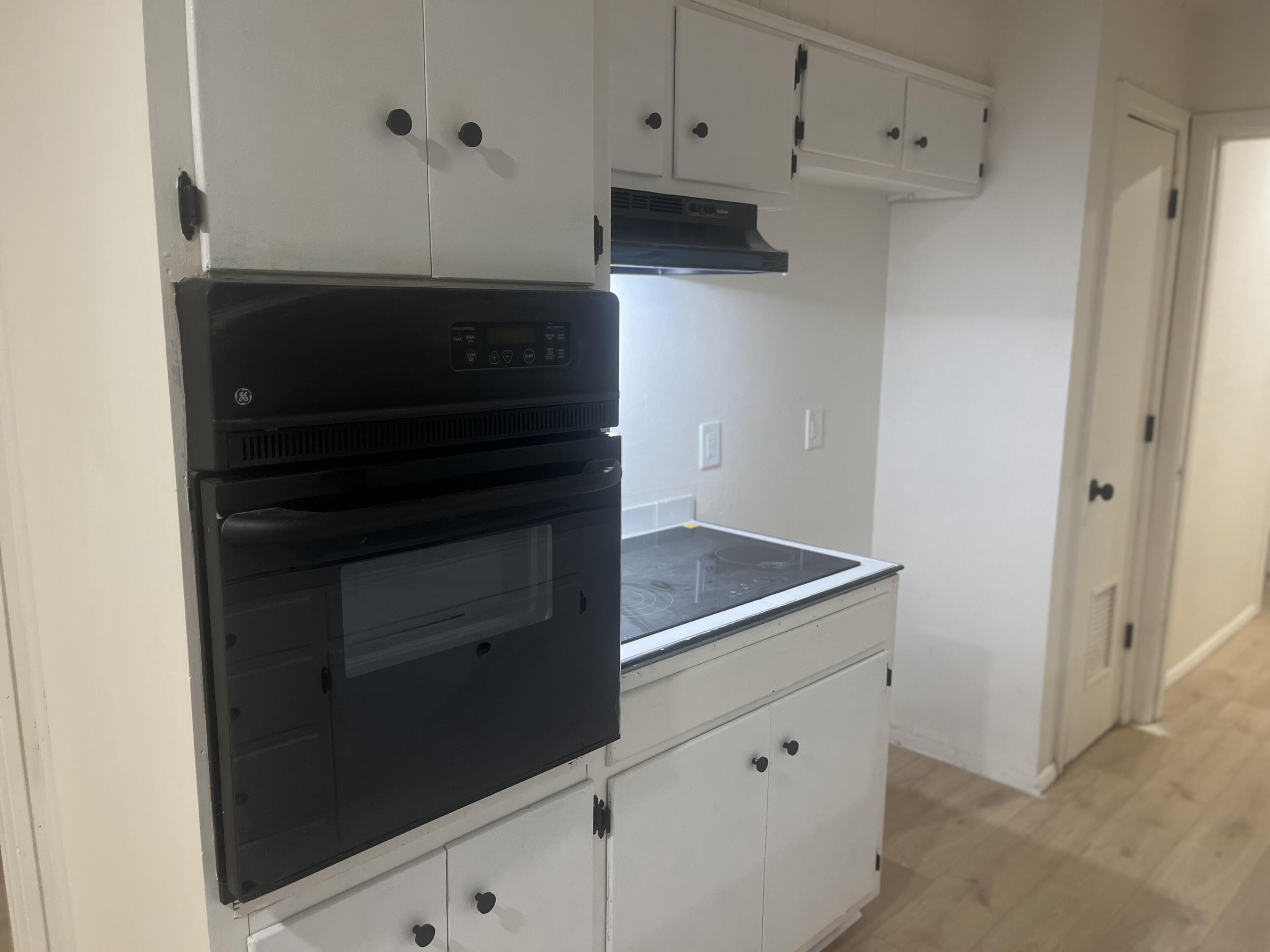1906 70th Street Lubbock, TX 79412 - Photo 9 of 27 a kitchen with white cabinets and black appliances