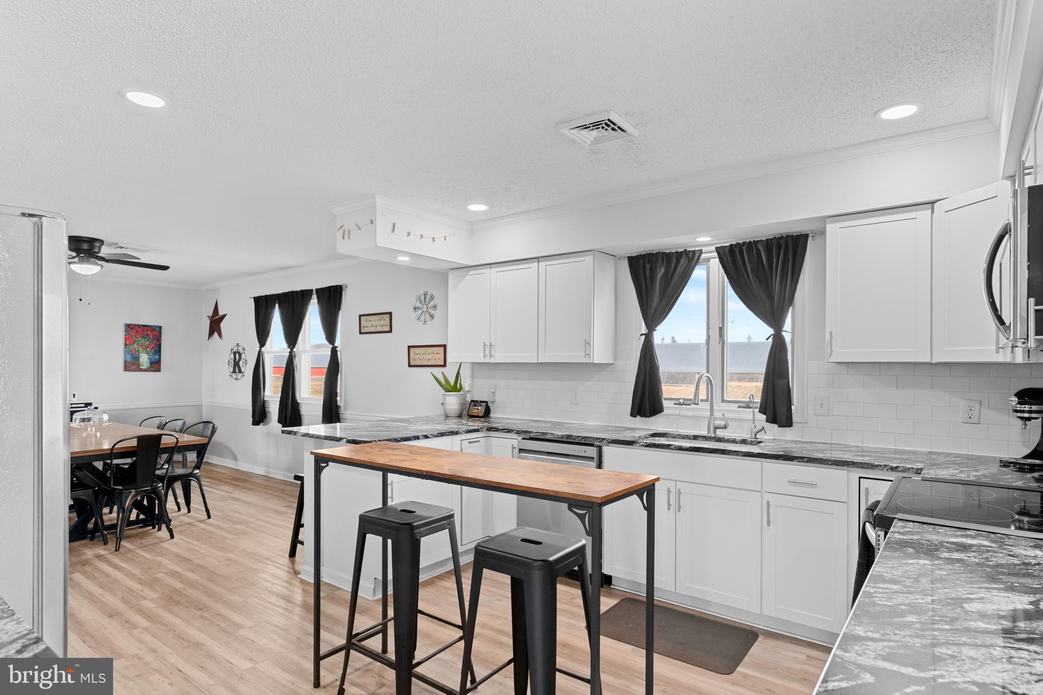 13171 Shiloh Church Road Laurel, DE 19956 - Photo 14 of 42 a kitchen with stainless steel appliances kitchen island granite countertop a table chairs in it and wooden floors
