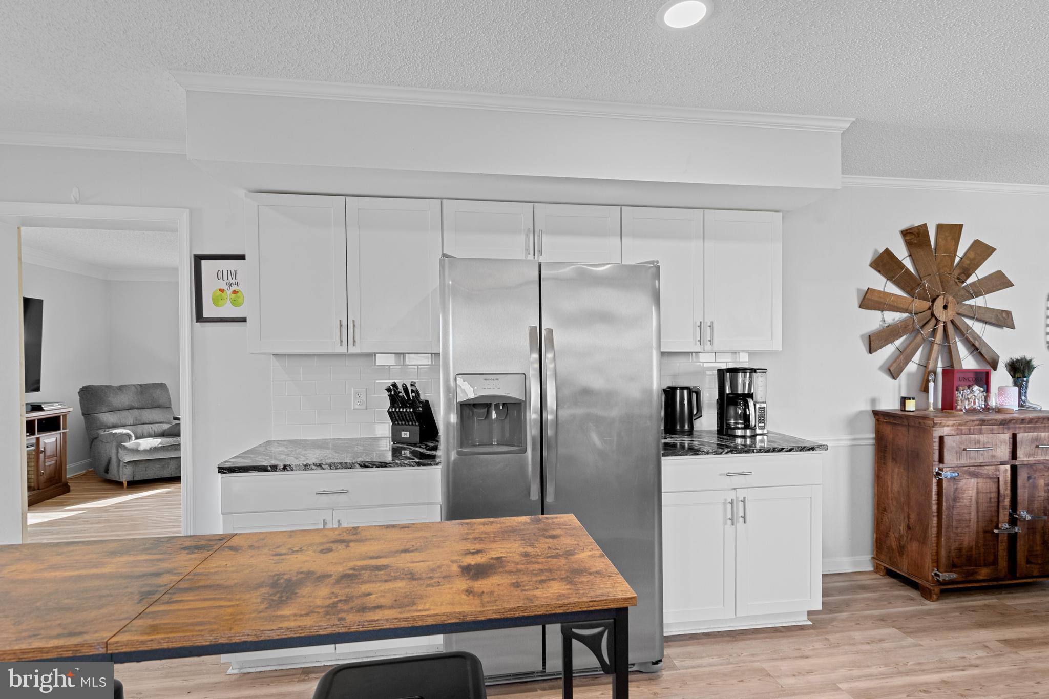 13171 Shiloh Church Road Laurel, DE 19956 - Photo 10 of 42 a kitchen with stainless steel appliances kitchen island granite countertop a refrigerator a stove and white cabinets with wooden floor