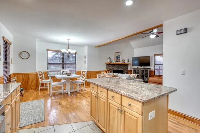 a kitchen with stainless steel appliances granite countertop a stove top oven a sink and a refrigerator