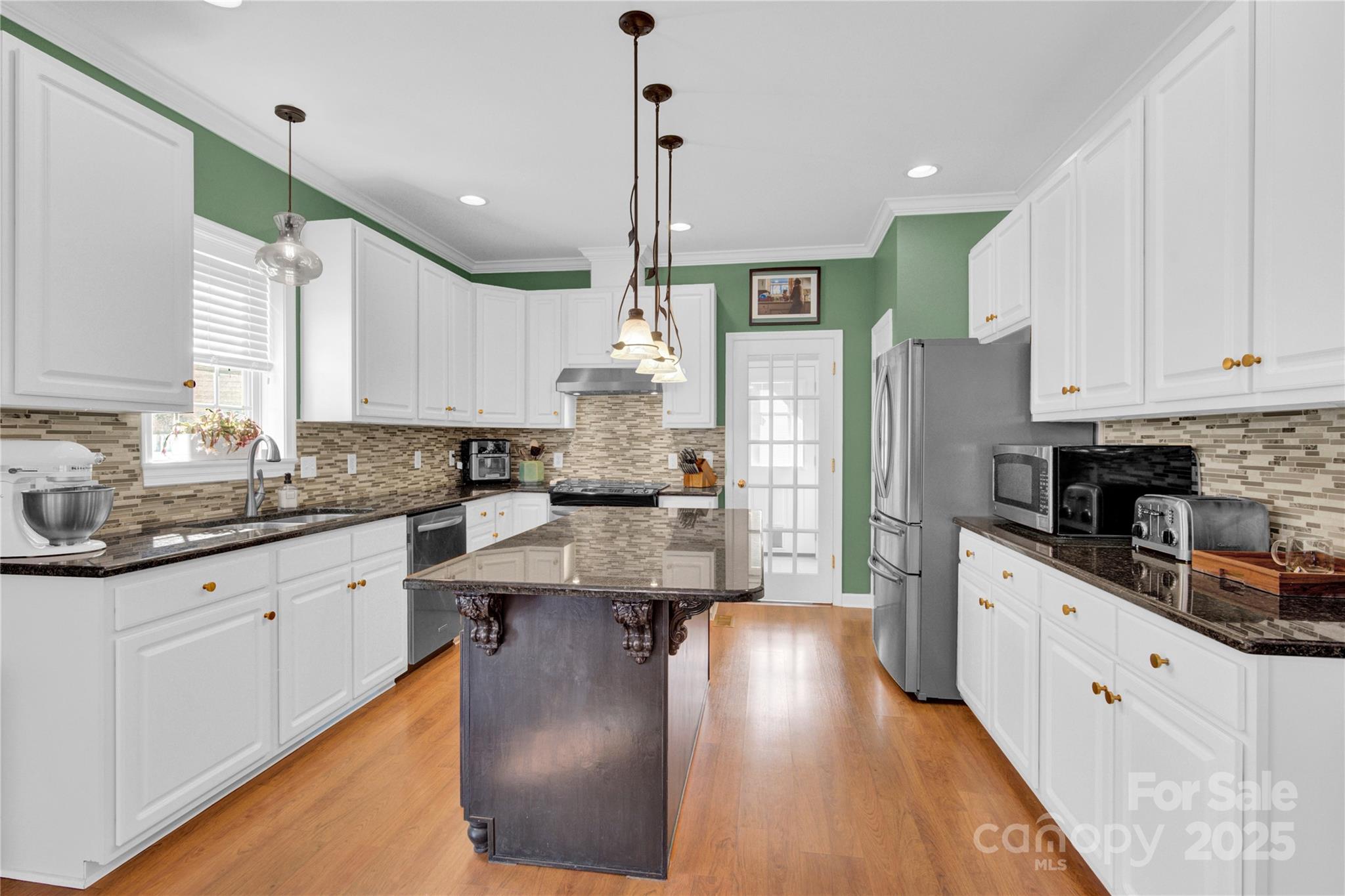 2441 27th Ave Circle Northeast Hickory, NC 28601 - Photo 24 of 45 a kitchen with stainless steel appliances kitchen island granite countertop a refrigerator a sink dishwasher a stove and white cabinets with wooden floor