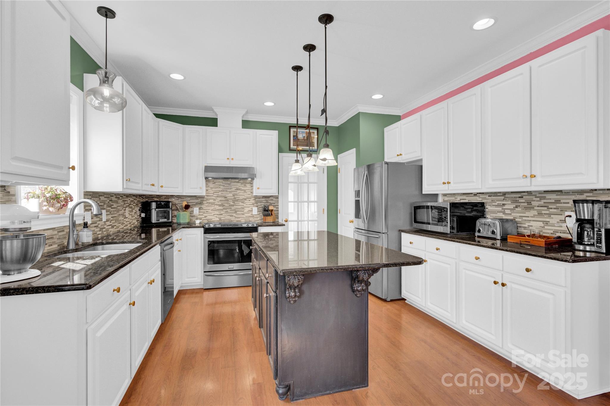 2441 27th Ave Circle Northeast Hickory, NC 28601 - Photo 25 of 45 a large kitchen with stainless steel appliances granite countertop a stove a sink a refrigerator and white cabinets with wooden floor