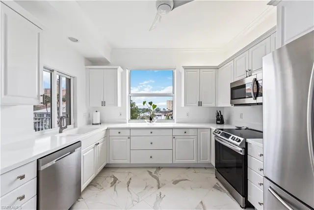 a kitchen with white cabinets and appliances