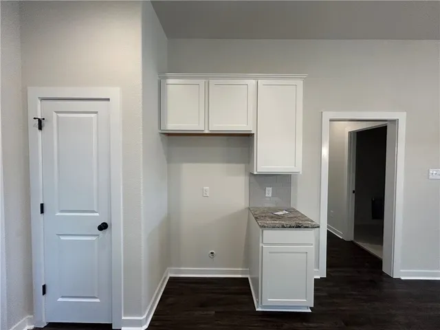 a kitchen with a refrigerator stove and white cabinets