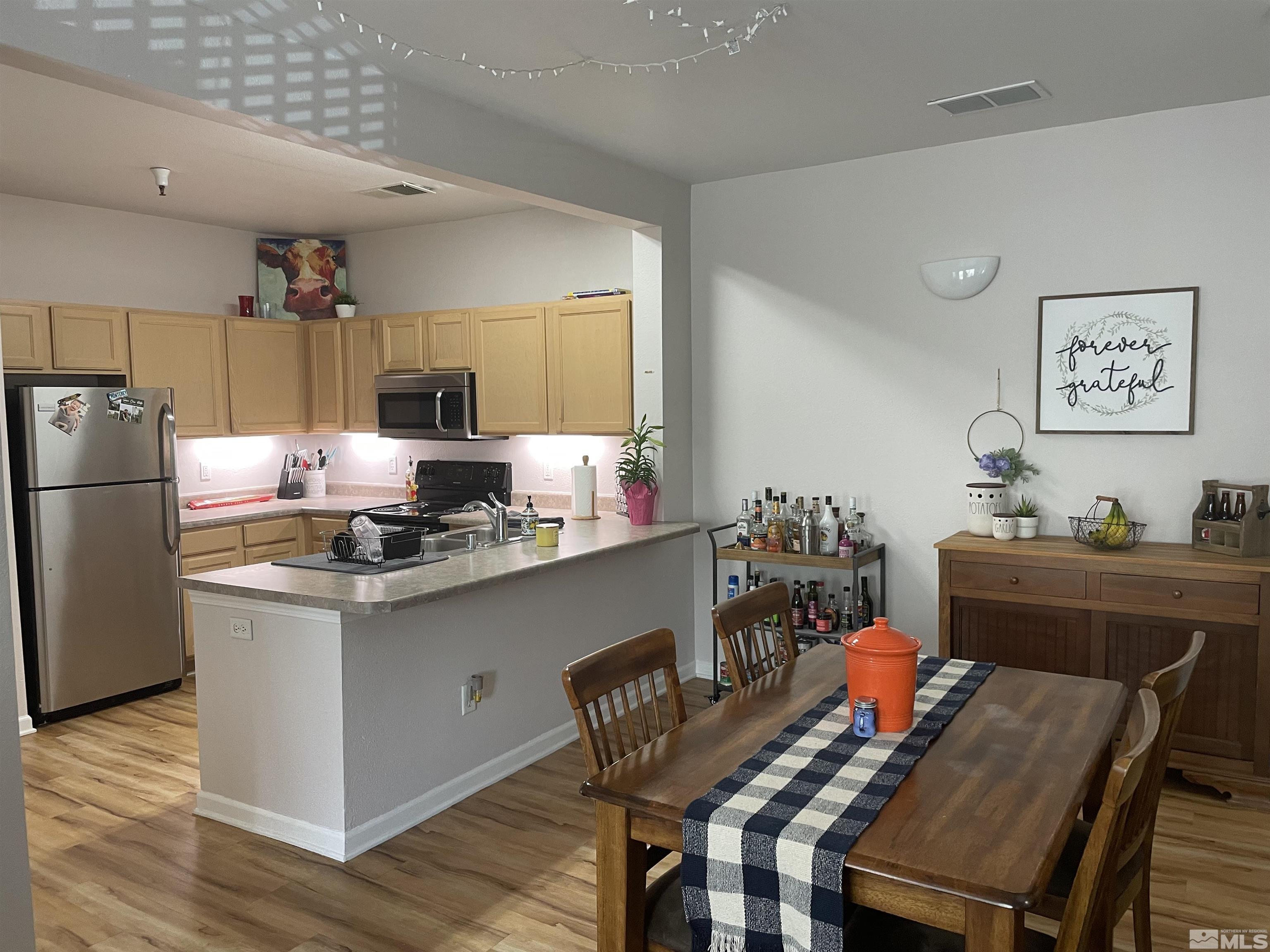 200 Talus Way, Unit 421 Reno, NV 89503 - Photo 5 of 23 a kitchen with granite countertop a table chairs stove and refrigerator