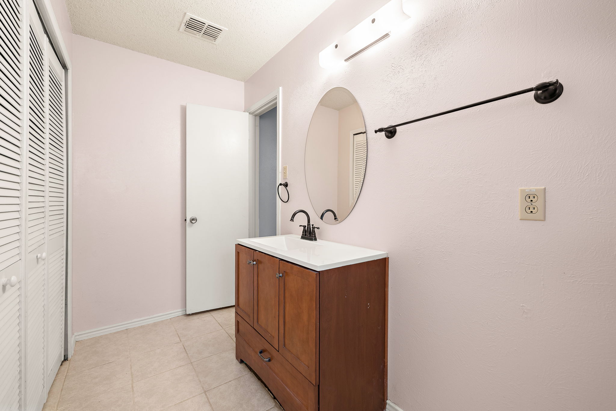 11709 Rotherham Drive Austin, TX 78753 - Photo 15 of 25 A well-lit bathroom with a wooden vanity and a mirror, offering a functional space.