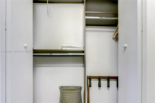 a view of a white house with a yard plants and large tree