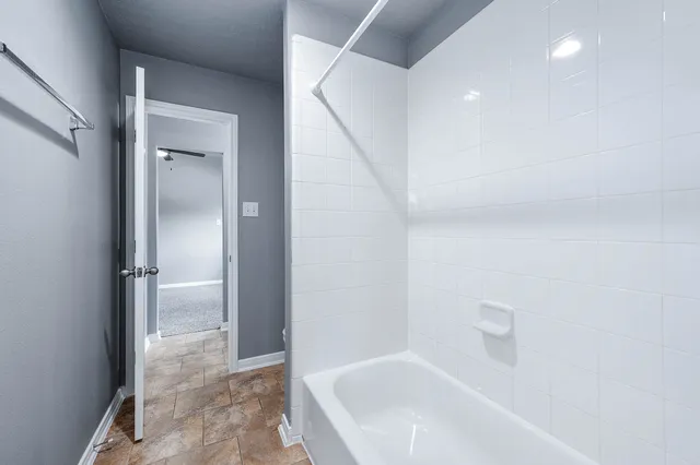 a view of a brick house with a large windows plants and large trees