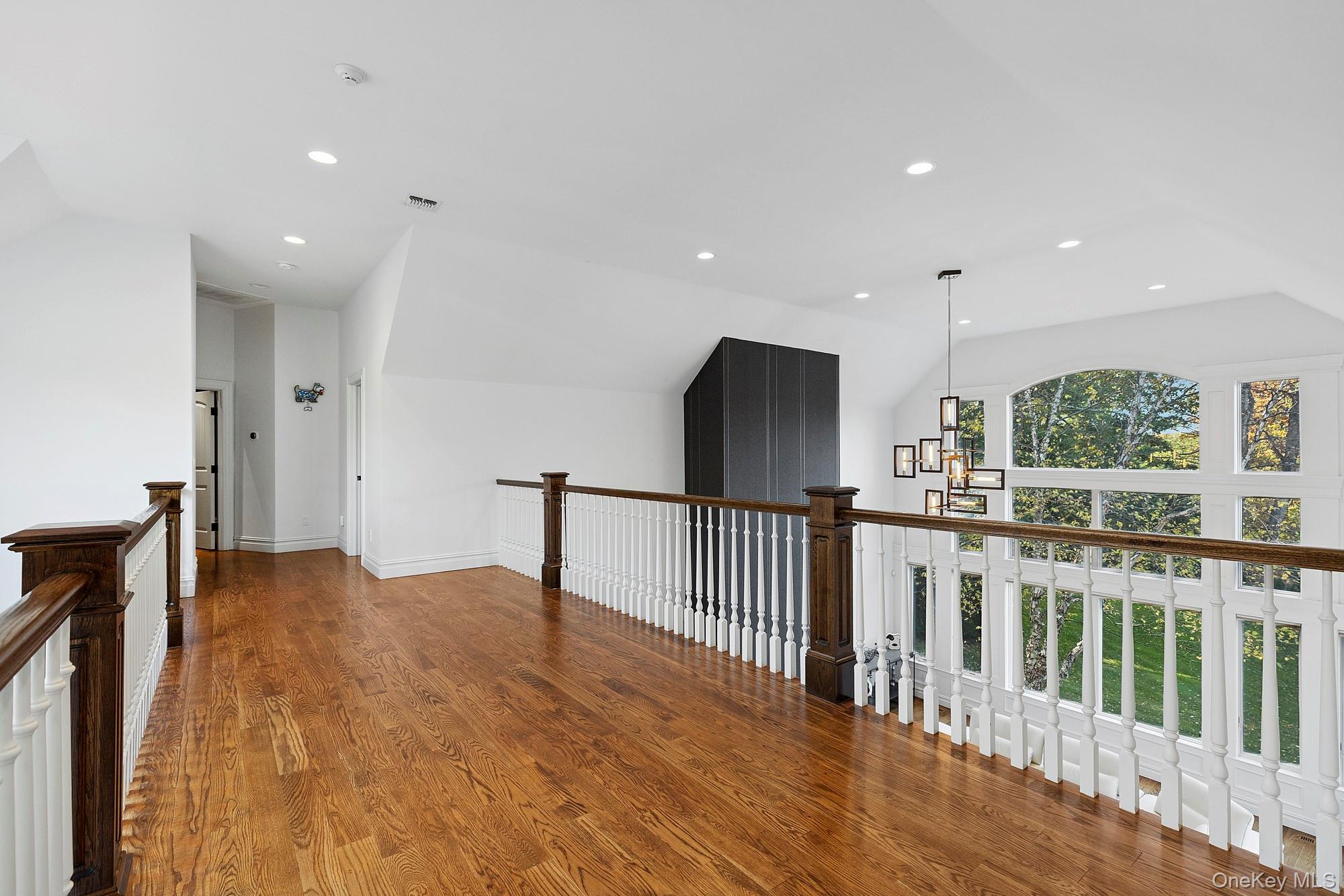 144 Round Swamp Road West Hills, NY 11743 - Photo 19 of 39 Hall featuring lofted ceiling, recessed lighting, dark wood finished floors, a chandelier, and an upstairs landing