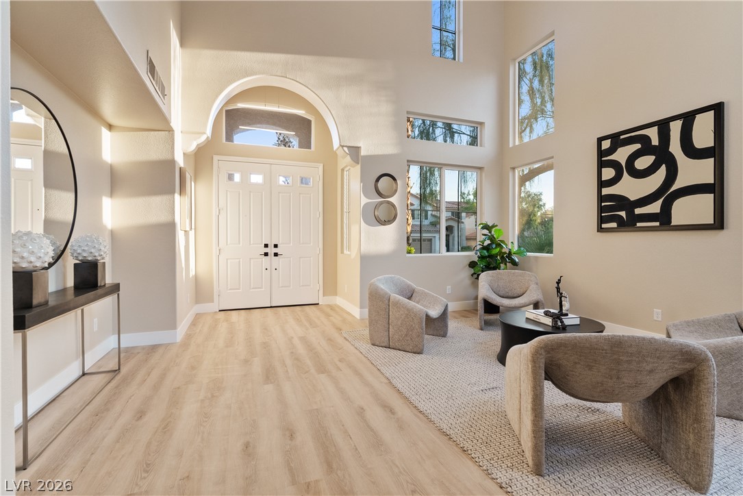 1662 Ravanusa Drive Henderson, NV 89052 - Photo 56 of 74 A luminous living space features towering ceilings, light wood floors, and a welcoming double-door entry.