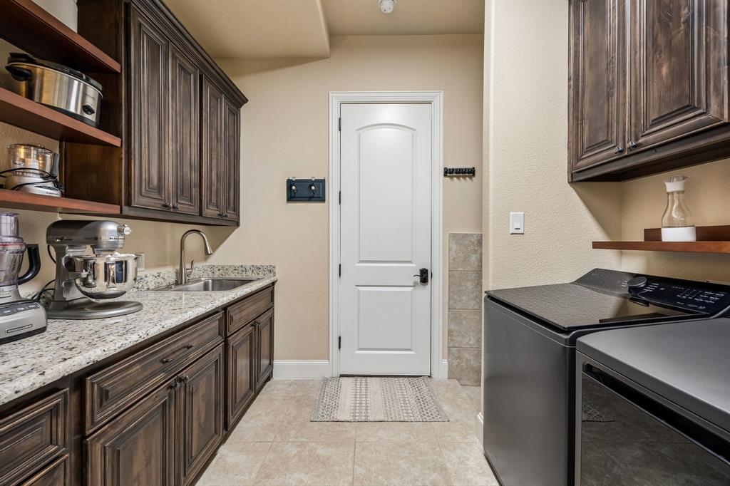 1005 Berkshire Road Southlake, TX 76092 - Photo 29 of 40 a kitchen with stainless steel appliances granite countertop a sink stove and cabinets