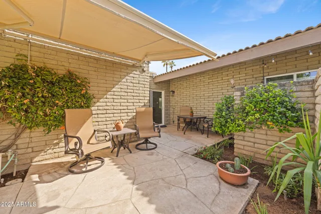 a view of a patio with chairs and potted plants