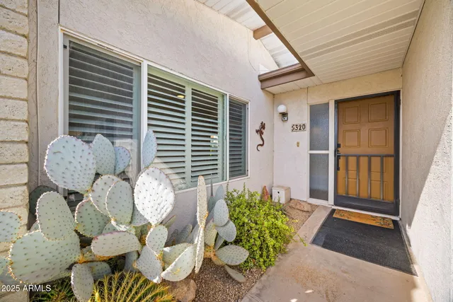 a front view of a house with large windows and plants