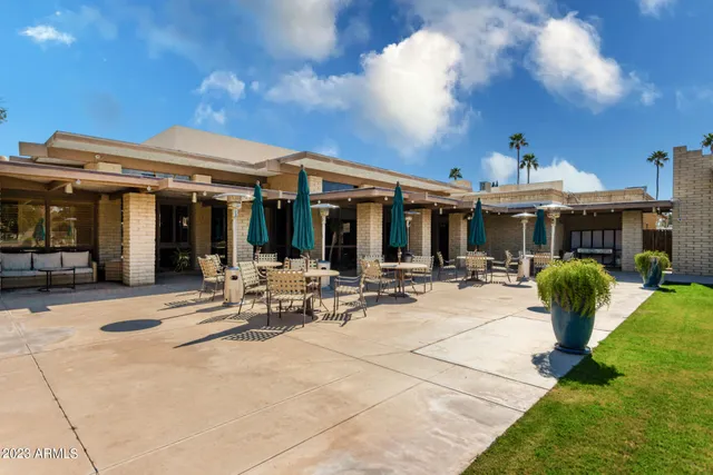 a view of a patio with dining table and chairs under an umbrella
