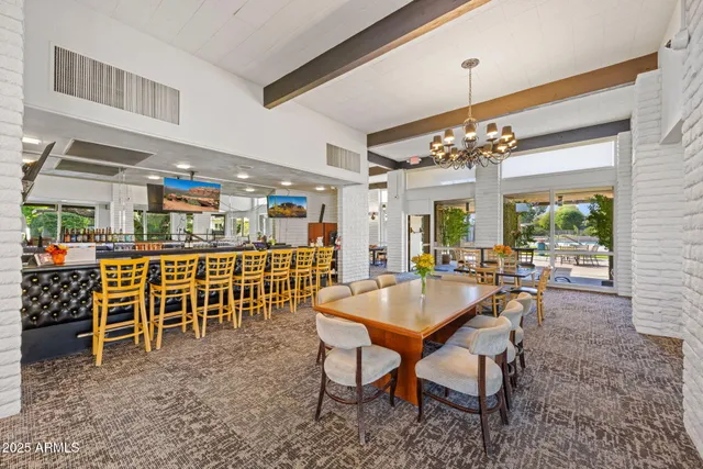 a dining room with furniture a chandelier and window