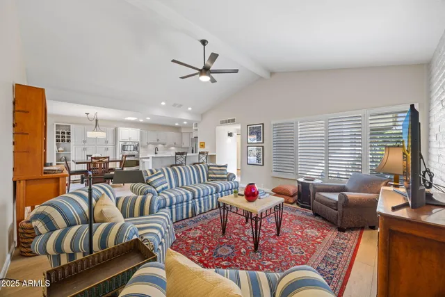 a living room with furniture kitchen view and a window