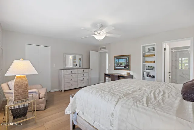 a spacious bedroom with a bed and a chair