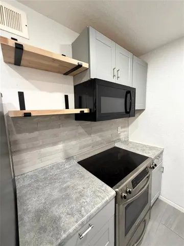 a kitchen with granite countertop a sink and a stove top oven