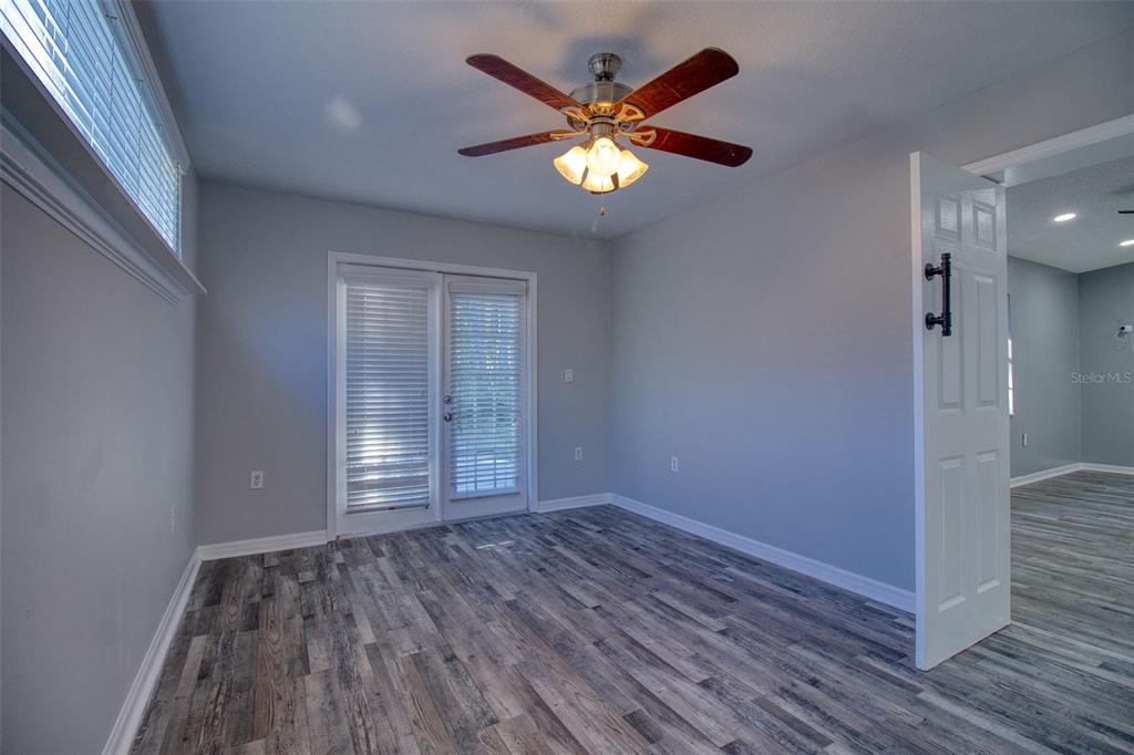 8122 Matthew Drive New Port Richey, FL 34653 - Photo 16 of 25 a view of an empty room with wooden floor and a chandelier