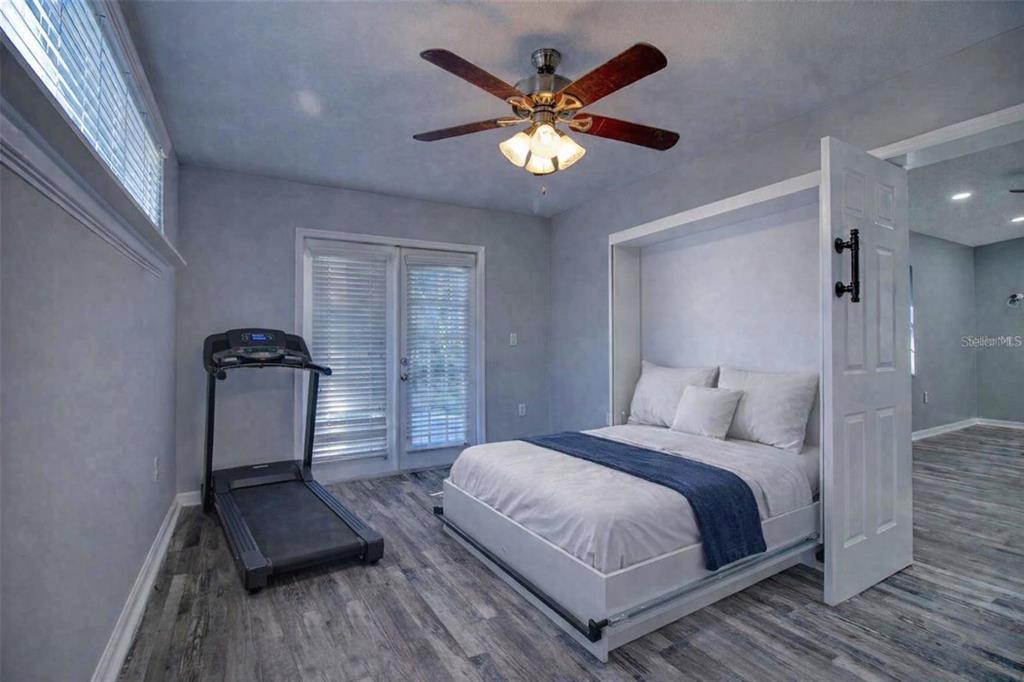 8122 Matthew Drive New Port Richey, FL 34653 - Photo 18 of 25 a bedroom with a bed and a chandelier