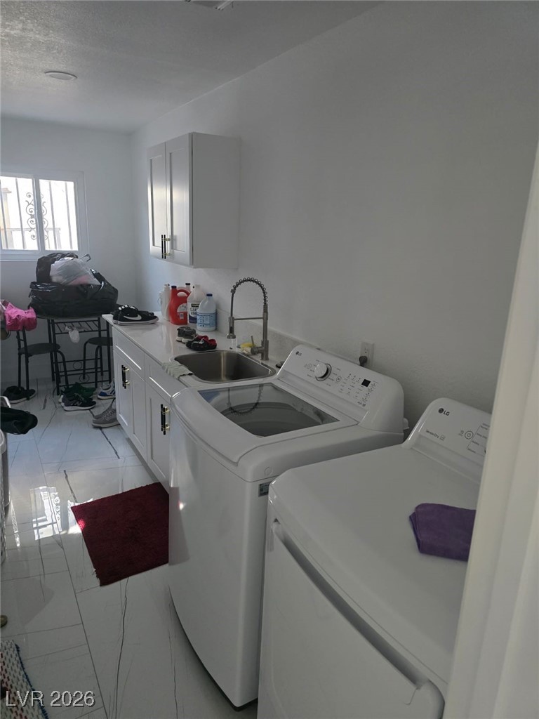 3153 Downing Place Las Vegas, NV 89121 - Photo 6 of 7 Washroom featuring cabinet space, separate washer and dryer, and a textured ceiling