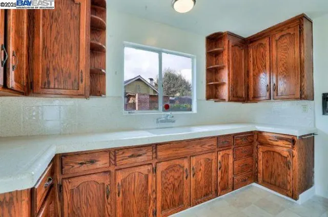 a kitchen with stainless steel appliances a sink cabinets and a window