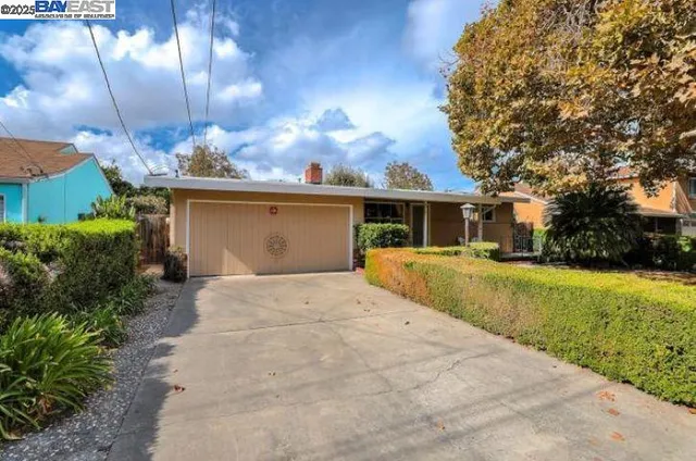 a front view of house with yard and trees around
