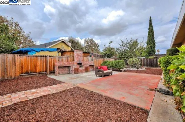 a view of a house with backyard and a tree