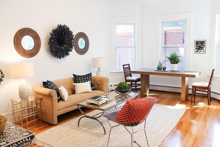 a living room with furniture a rug and a wall painting