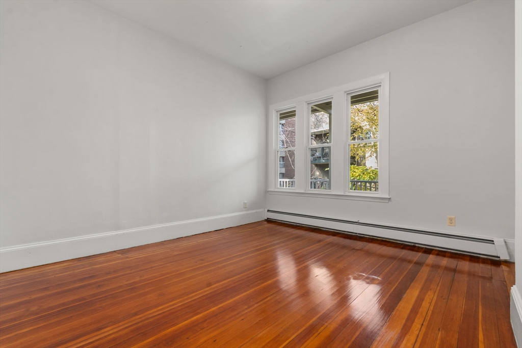 15 Trowbridge Street, Unit 8 Cambridge, MA 02138 - Photo 15 of 17 an empty room with wooden floor and windows