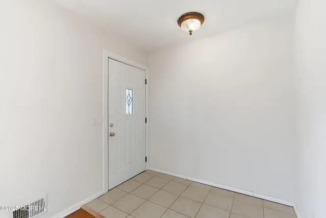 a kitchen with stainless steel appliances granite countertop a refrigerator a stove and white cabinets with wooden floor