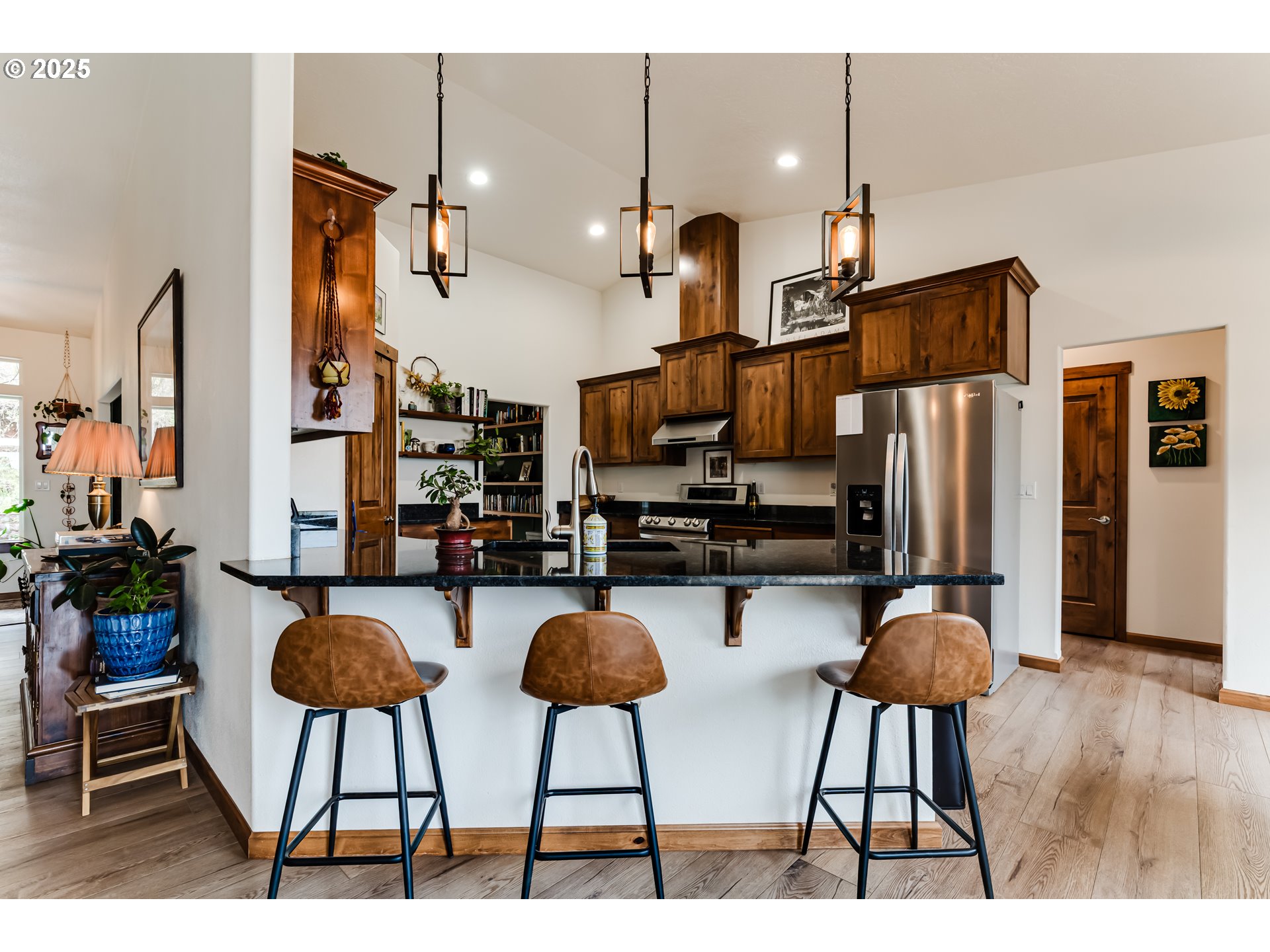 31490 Fox Hollow Road Eugene, OR 97405 - Photo 14 of 40 a kitchen with stainless steel appliances kitchen island granite countertop a refrigerator a stove a kitchen island a dining table and chairs with wooden floor