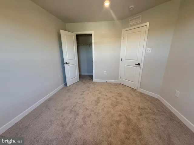 a view of an empty room and closet area